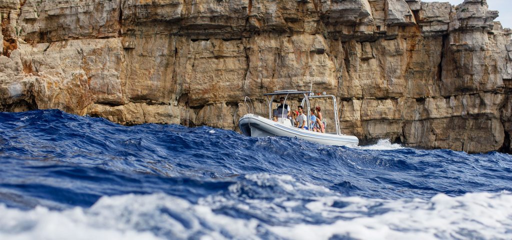 Archipelago Tours Blog and Tips: Carved by the elements - photo of our boat under one of the cliffs in Kornati archipelago